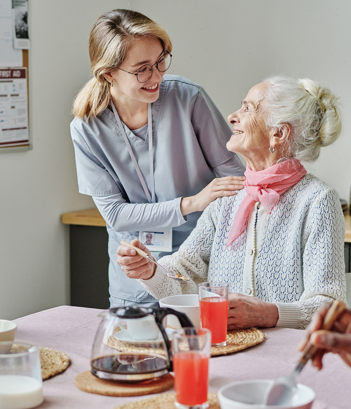 Caregiver helping senior people during lunch